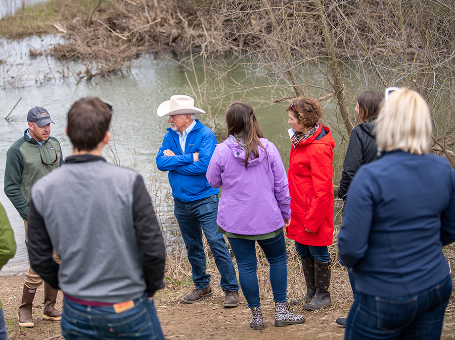 California Water Commissioner Joe Del Bosque, center, in hat, listens to Field and Lab Director Carson Jeffres, PhD, left of the Center for Watershed Sciences, University of California, Davis, during a tour of the Oneto-Denier Floodplain Restoration Project in the Cosumnes River Watershed near Galt.