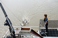 DWR environmental scientist Morgan Martinez checks specialized netting and water collection containers while taking water samples from the Sacramento-San Joaquin Delta on DWR's research vessel the Sentinel.