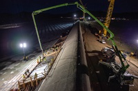 Before sunrise, workers from Kiewit Infrastructure pump structural concrete into forms as part of the finish work on the first section of a new concrete cap below the Lake Oroville emergency spillway weir.