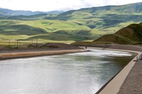 A section of the California Aqueduct within the California State Water Project, located near Wheeler Ridge, which convey California Aqueduct water between Ira J. Chrisman Wind Gap and Edmonston Pumping Plants within Kern County. In the background is the Tehachapi Mountains.
